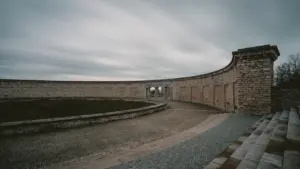 Die Gedenkstätte Buchenwald bei Weimar mit ihrer charakteristischen steinernen Mauer unter bewölktem Himmel.