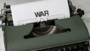 Eine historische Schreibmaschine mit dem Wort 'WAR' auf einem eingespannten Blatt Papier.