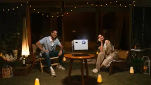 Ein Paar genießt einen entspannten Filmabend im Freien mit einem modernen Projektor.