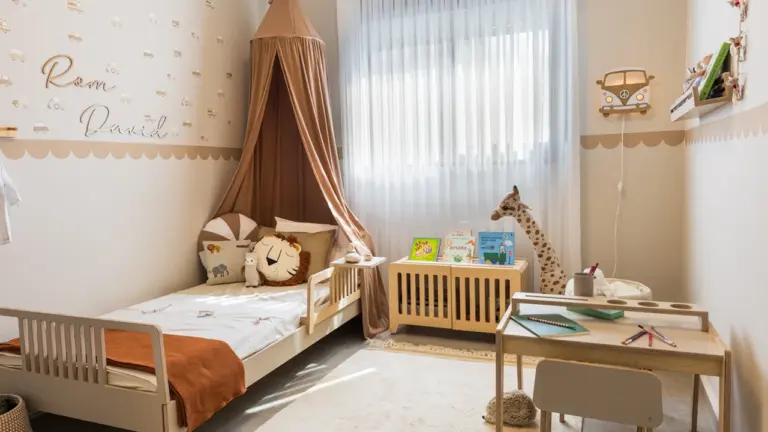 Gemütliches Kinderzimmer mit Himmelbett und Schreibtisch in sanften Erdtönen gestaltet.