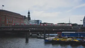 Eine S-Bahn überquert eine Hamburger Brücke über die Elbe bei bewölktem Tageslicht.