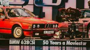 Klassischer roter BMW und eine professionelle Filmkamera als Exponat in einer Ausstellung.