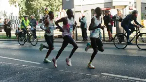 Profisportler laufen bei einem Marathonrennen auf einer belebten Berliner Stadtstraße.