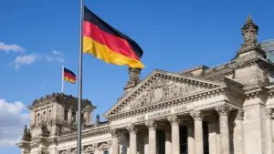 Die deutsche Flagge weht stolz vor dem historischen Reichstagsgebäude in Berlin.