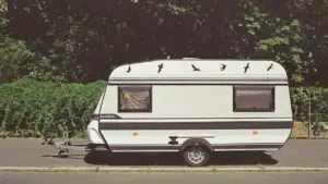 Weißer Wohnwagen parkt an einer Straße, ideal für Berichte über Camping-Fehlkäufe.