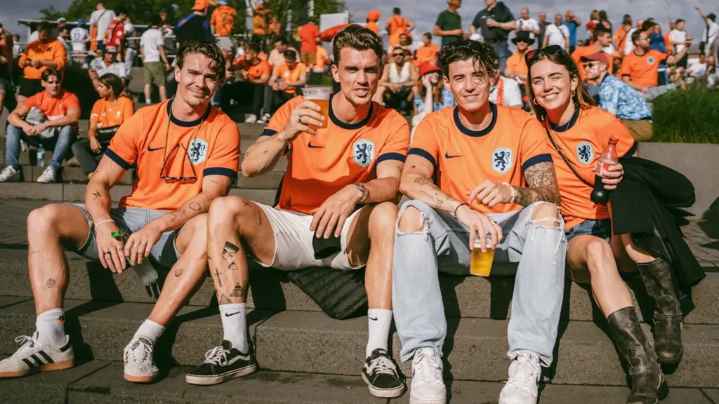 Niederländische Fußballfans in orangefarbenen Trikots bei bester Stimmung vor einem großen Spiel.