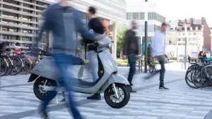 Elektroroller und Fußgänger in einer modernen deutschen Stadt während der Mobilitätswoche.