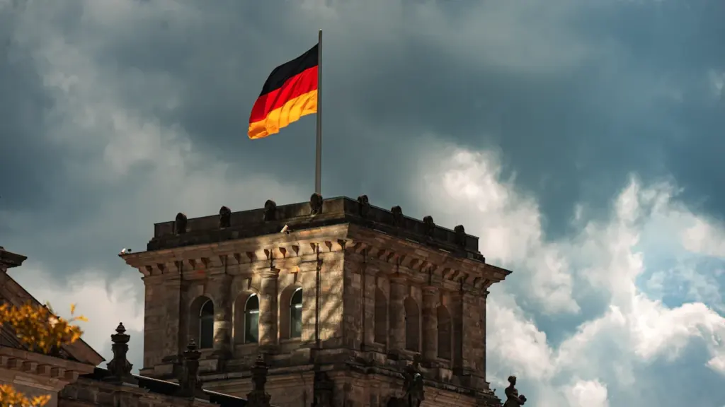 Die deutsche Flagge weht stolz über dem historischen Gebäude des Reichstags in Berlin.